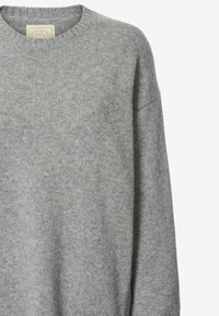 Hellgrauer Pullover aus weichem Strickmaterial. Er hat einen runden Halsausschnitt und überschnittene Schulternähte, mit einer glatten, strukturierten Oberfläche.