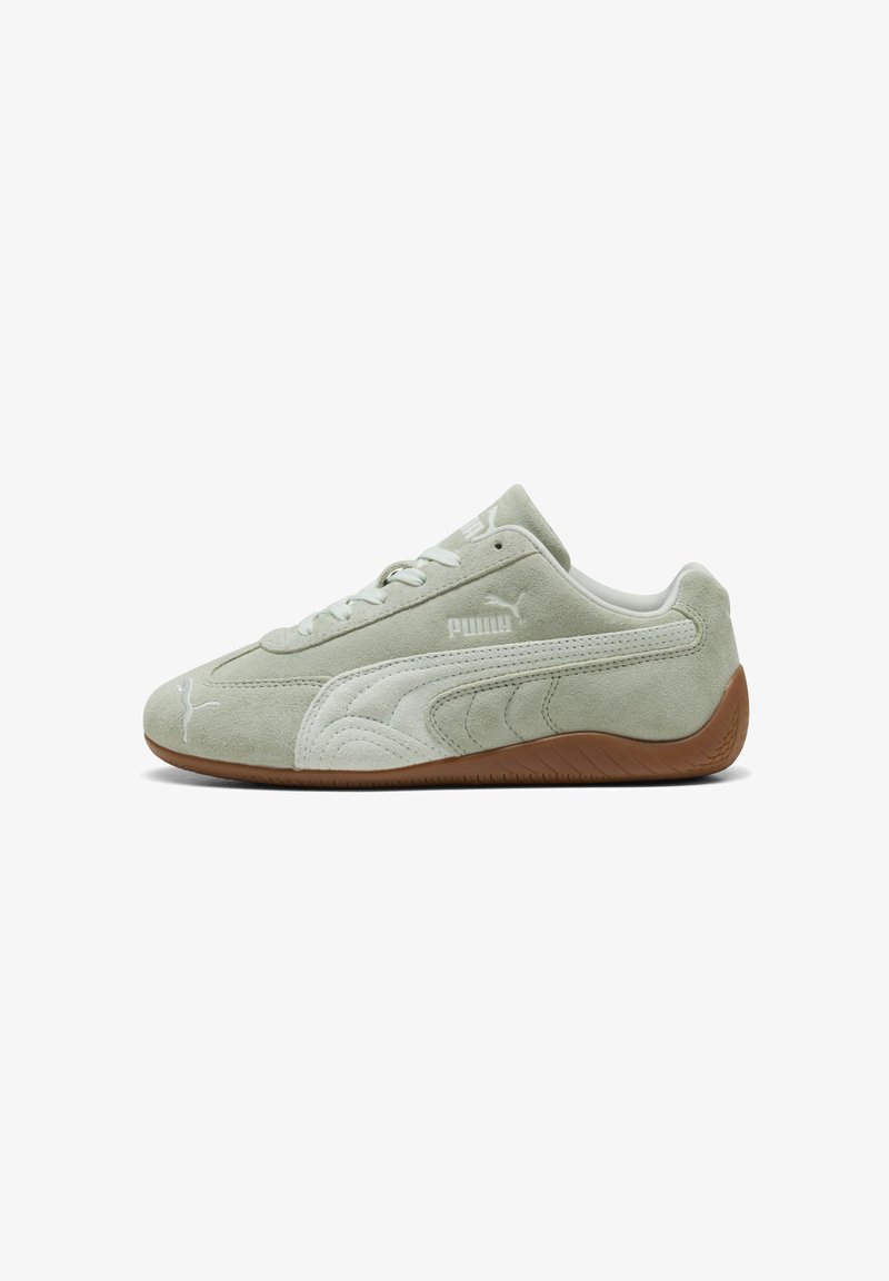 Αθλητικό παπούτσι Puma ανοιχτού πράσινου χρώματος από σουέντ με λευκές ρίγες και καφέ λαστιχένια σόλα, όπως φαίνεται από την εξωτερική πλευρά.