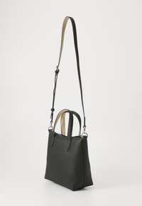 Black leather handbag with a textured finish, dual top handles, and an adjustable shoulder strap in contrasting beige color.