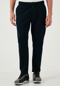 Marineblauwe sport joggers met een elastische tailleband en trekkoord. Gemaakt van zachte stof, met een taps toelopende pasvorm en zijzakken.