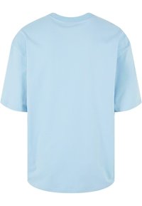Tricou scurt de culoare albastră deschis, cu mâneci scurte, guler rotund și un material neted și moale. Fără grafice sau detalii suplimentare vizibile.