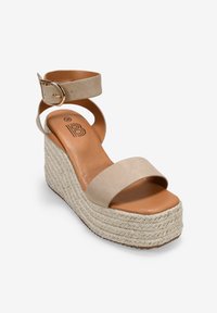 Sandale en wedge beige avec une semelle en jute texturé, une bride de cheville avec une boucle métallique et une large bande avant. Dessus et semelle intérieure en simili cuir lisse.
