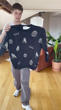 Čierna mikina s Yale tématikou, na bielom podklade obsahujúca logá a maskoty, s klasickým okrúhlym výstrihom a rebrovanými manžetami.