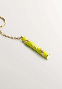 Llavero con un vibrante diseño en forma de bambú verde, con acentos dorados y patrones de hojas. Incluye una cadena dorada y un anillo de sujeción.