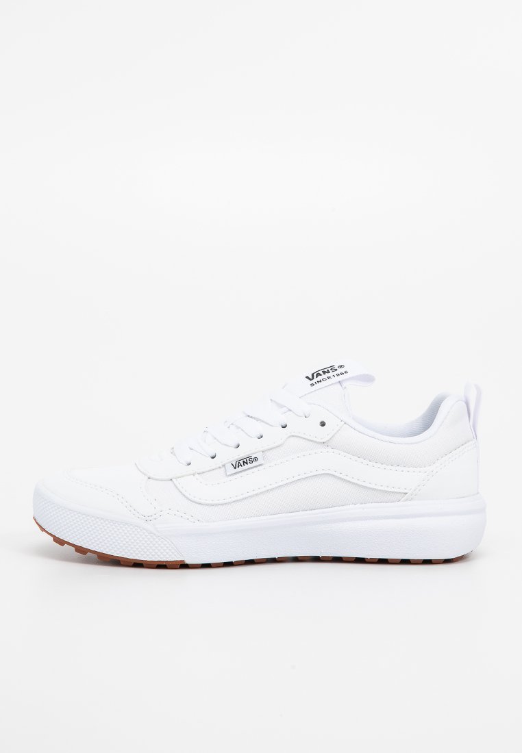 Zapatillas blancas con parte superior de cuero suave y lona, punta redonda, suela de goma blanca gruesa y cierre de cordones. Presenta el logo de Vans en el costado.