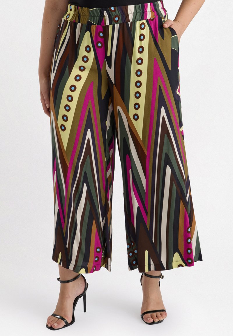 Vida byxor med vida ben i ett färgglatt zigzag-mönster med nyanser av brunt, grönt, rosa och kräm, accentuerade med blå knappar och fickor.