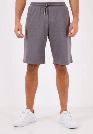 Grå atletiske shorts lavet af blødt stof, med en elastisk talje og snor, sidelommer og en afslappet pasform.