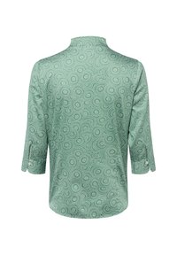 Groene blouse met een draaiend wit patroon, voorzien van een opstaande kraag en driekwart mouwen met knoopdetail. Zachte stoftextuur.