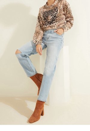 Mikina s leopardím potiskem a černými akcenty, světle modré roztrhané džíny a hnědé semišové kotníkové boty se čtveratými špičkami a blokovým podpatkem.
