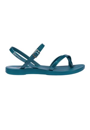 Flache türkise Sandale mit dünnen Riemen, einer verstellbaren Schnalle und einer strukturierten Sohle, entworfen für den Freizeitgebrauch.