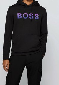 Černá mikina s kapucí z bavlněné směsi, s přední kapsou a fialovým gradientním logem "BOSS" přes hrudník.