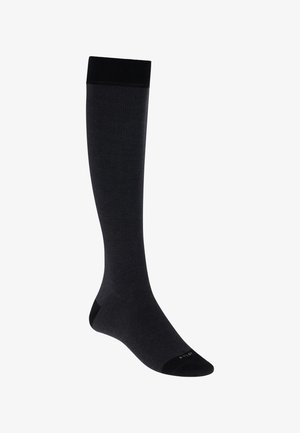 Ein einzelner schwarzer knielanger Strumpf mit verstärkter Spitze und Bündchen, vor weißem Hintergrund dargestellt.