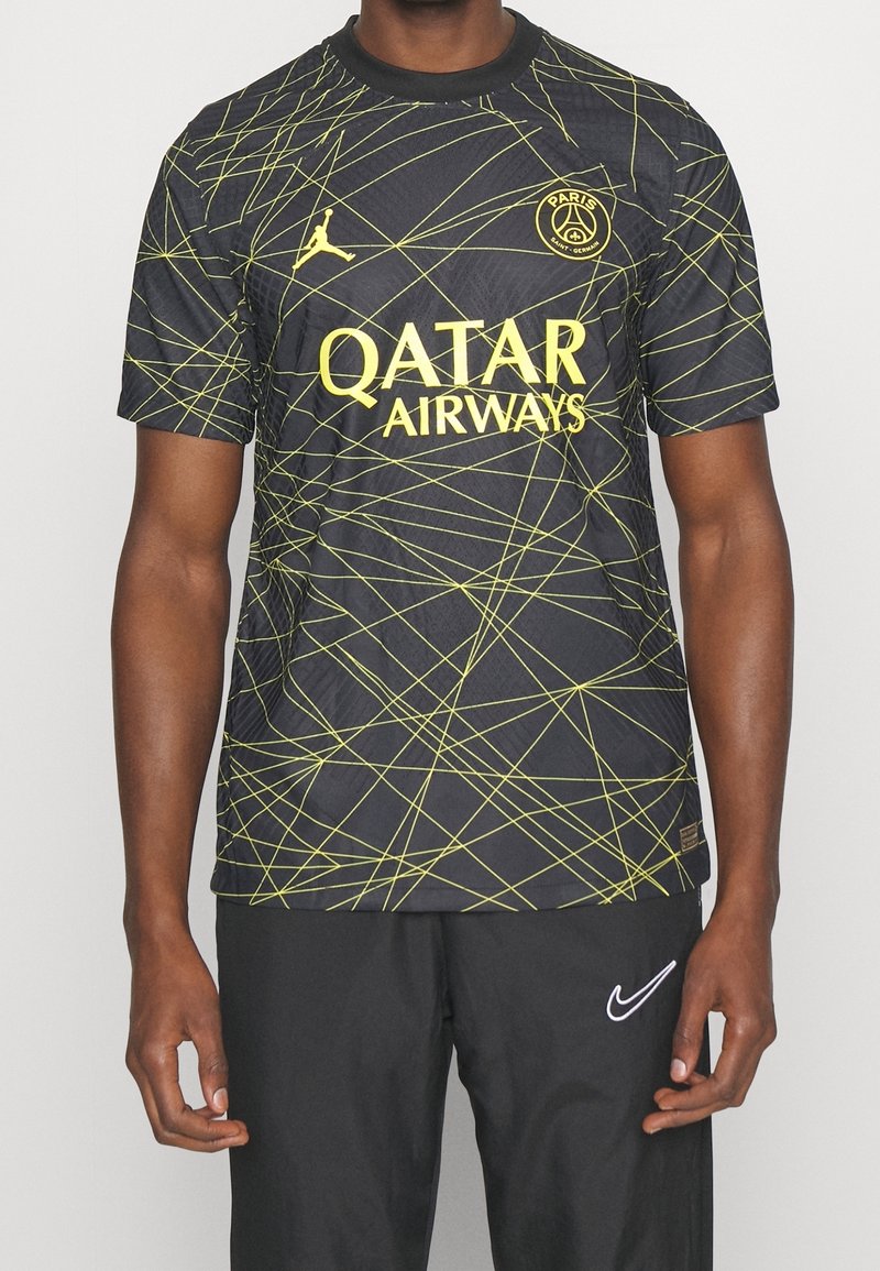 Maglia nera con linee geometriche gialle, con il logo Jordan e la scritta "Qatar Airways" ben visibili. Maniche corte, scollo rotondo.