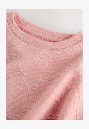 Pull rose texturé présentant un motif tissé subtil de nœuds, un col côtelé et un tissu doux et confortable.