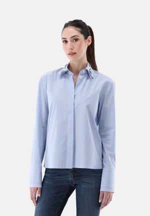 Blue striped button-up shirt with white and yellow vertical stripes, features a collar with embellishments, long sleeves, and a relaxed fit.