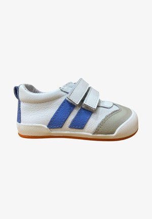 Zapatilla blanca y azul con dos tiras de velcro, parte superior de cuero, puntera redondeada y suela texturizada con un fondo de goma color marrón.