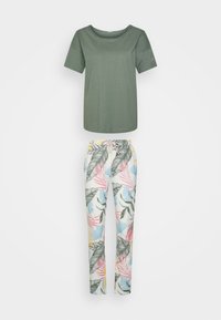 Camiseta de manga corta color verde oliva con cuello redondo, combinada con pantalones blancos que cuentan con un estampado floral en tonos rosas, azules y verdes.
