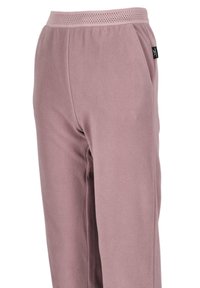 Fleece joggers in soft pink, featuring a textured surface, elastic waistband with perforations, and side pockets.