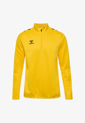 Gul pullover med lange ærmer og kvart lynlås krave. Har sorte detaljer og logo på brystet. Glat, letvægtsstof.