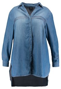 Chemise en denim dotée d'un col à revers, de manches longues, d'une fermeture à boutons sur le devant, d'un ourlet arrondi et de fentes latérales ; couleur bleu clair avec des détails texturés.