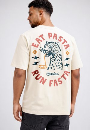Man wearing a cream t-shirt with a leopard eating pasta graphic and the text "EAT PASTA RUN FASTA" on the back.