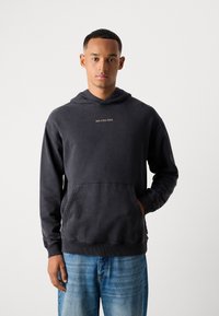 Mørkegrå bomulds hoodie med lomme på forsiden, riflet manchetter og et lille logo på brystet. Casual pasform og blød tekstur.