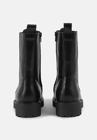 Zwarte leren enkelboots met een strak ontwerp, ronde neuzen en rubberen zolen met een profiel. Voorzien van achterste trekhaakjes en zijritsen.