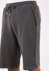 Grå atletiske shorts lavet af tekstureret stof, med elastisk talje, snøre lukning og sidelommer.