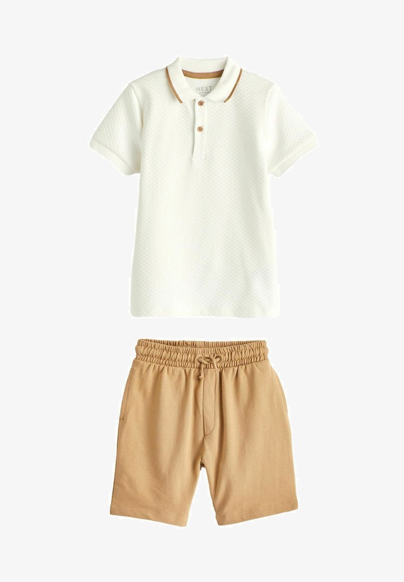 Polo blanc texturé à manches courtes avec des accents de col marron, associé à un short beige avec cordon de serrage et poches.