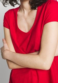 T-shirt rosso a maniche corte con scollatura rotonda. Realizzato in un tessuto leggero e testurizzato, presenta una vestibilità rilassata.