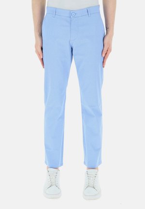 Pantaloni azzurri chiari con una trama testurizzata, dotati di chiusura a bottone, passanti per la cintura e design a vestibilità slim. Indossati con sneakers bianche.