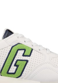 Weißer Sneaker mit perforiertem Leder, marinefarbenen Akzenten und einem grünen, gestickten "G"-Logo an der Seite. Strukturiertes und schnürbares Design.