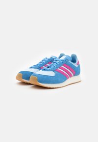 Blue and pink sneakers made of suede and mesh, featuring three pink stripes, a white midsole, and a textured gum rubber outsole.