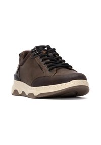 Zapatilla de cuero marrón con cordones negros, que presenta una suela beige acolchada y acentos texturizados. Forma redondeada, construcción robusta.