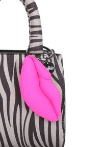 Borsa a tracolla a motivo zebra in tessuto grigio e nero, con un charm a forma di labbra rosa e una maniglia robusta. I dettagli includono un anello metallico.