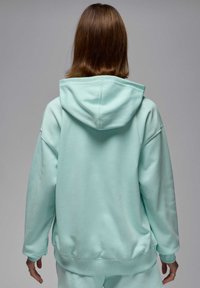 Sudadera mint green de gran tamaño con capucha ajustable, puños y dobladillo acanalados, que presenta una textura suave y un corte relajado.