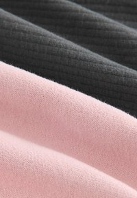 Trois échantillons de tissu : rose pâle, gris foncé et gris charbon texturé. Présente différentes textures et motifs de tricot.
