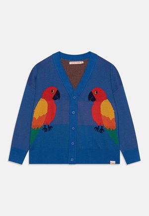 Cardigan bleu boutonné avec deux perroquets colorés se faisant face, avec des plumes rouges, jaunes, orange et vertes sur le devant.