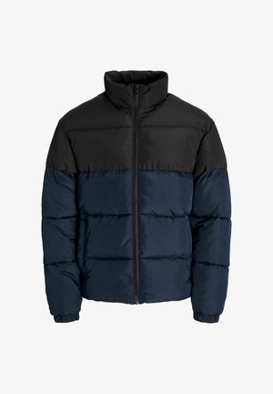 Jakna na preklop s crnim gornjim dijelom i tamnoplavo donjim dijelom. Izrađena od prošivenog materijala, ima visok ovratnik i elastične manžete.