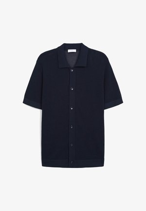 Chemise tricotée à manches courtes, couleur marine, avec col, fermeture à boutons et tissu texturé. Présente des poignets et un ourlet unis de couleur contrastée.