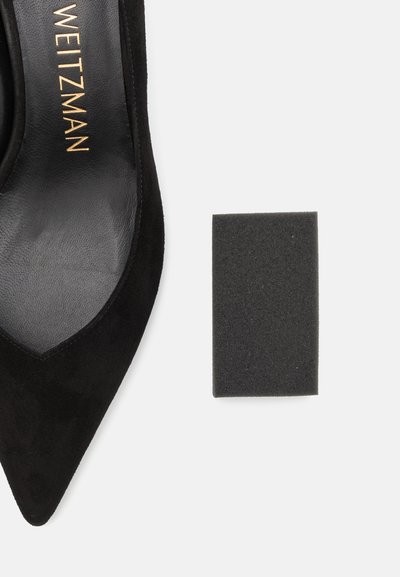 Musthave musta nahkakreeniga teravtoeline king, millel on sile sisemine vooder, koos musta neljakandilise vahtmaterjali tükiga, mis pakub pehmendust või tuge.