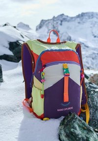 Colorful backpack with a mix of purple, red, yellow, and green panels. Features a front zipper pocket and adjustable straps. Branding visible.