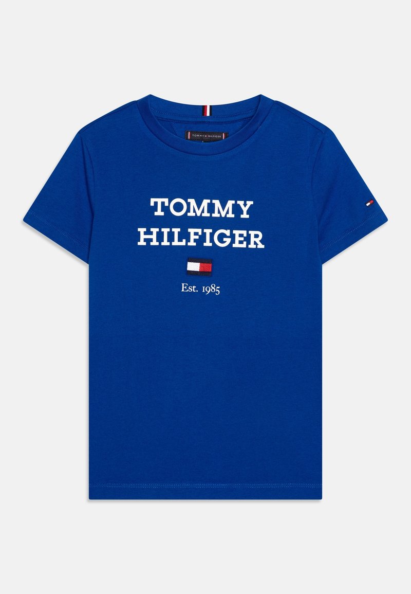 Modré bavlněné tričko s bílým logem "TOMMY HILFIGER", pod kterým se nachází malé vlajkové logo a text "Est. 1985". Krátké rukávy a kulatý výstřih.