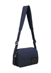 Borsa a tracolla blu navy con spallaccio imbottito e dettagli in metallo argentato. Presenta una chiusura con zip e un tessuto testurizzato. Logo "STUDIO BERLIN" sul davanti.
