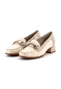 Mocasines de charol beige con punta cuadrada, tacón bajo estilo bloque y detalles de cadena en la parte superior. Acentos texturizados en los costados.