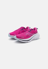 Chaussures de sport roses vives avec une tige en maille, une semelle blanche rembourrée et des accents noirs. Présente un logo de marque en évidence sur le côté.