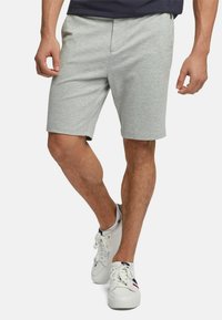 Gray cotton shorts with a smooth texture, featuring a front zip pocket and an elastic waistband. Paired with white sneakers.