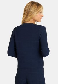 Navyblauer, strukturierter Pullover mit horizontalen Ripplinien und langen Ärmeln, Rundhalsausschnitt und tailliertem Design.