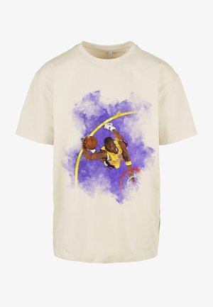 Beige T-Shirt mit kurzen Ärmeln, das ein farbenfrohes Grafikdesign eines Basketballspielers in der Luft vor einem lila Aquarell-Hintergrund zeigt.