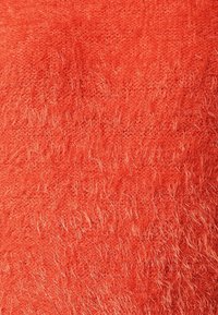 Dunigt, klart orange tyg med en mjuk, texturerad yta och lösa, fluffiga fibrer. Jämn färgning utan distinkta mönster eller accenter.